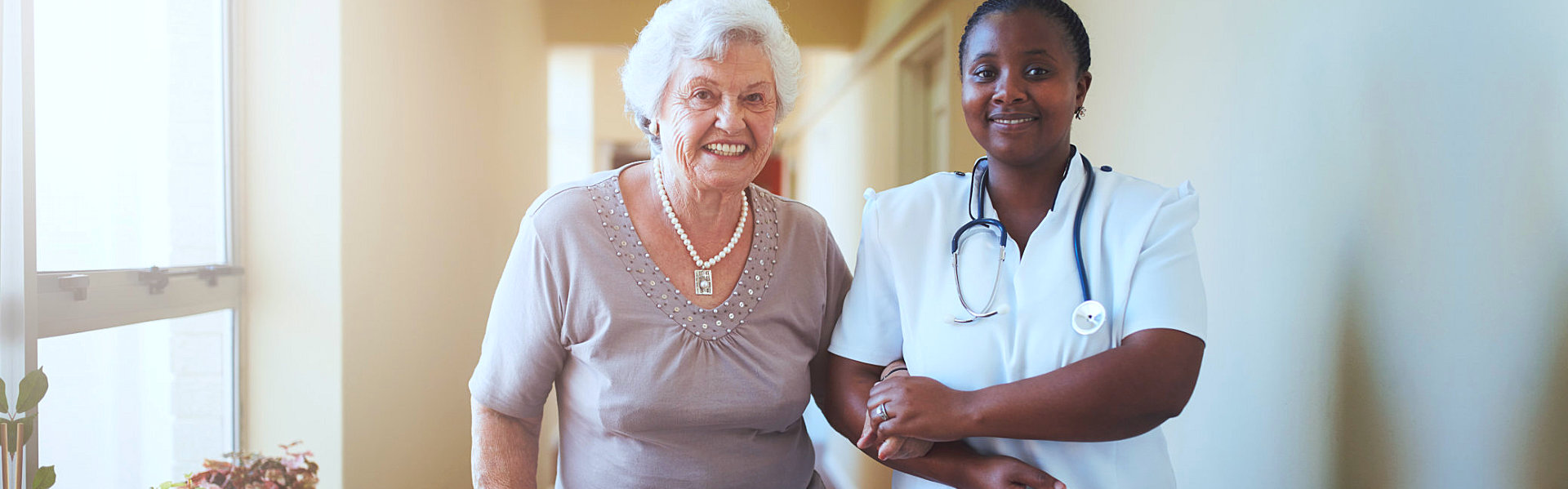 caregiver assisting her patient in walking