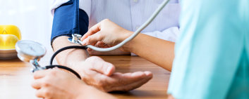 caregiver monitoring the patient's blood pressure